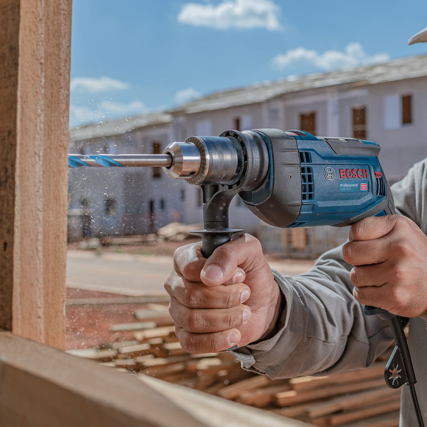 mãos segurando furadeira de impacto bosch