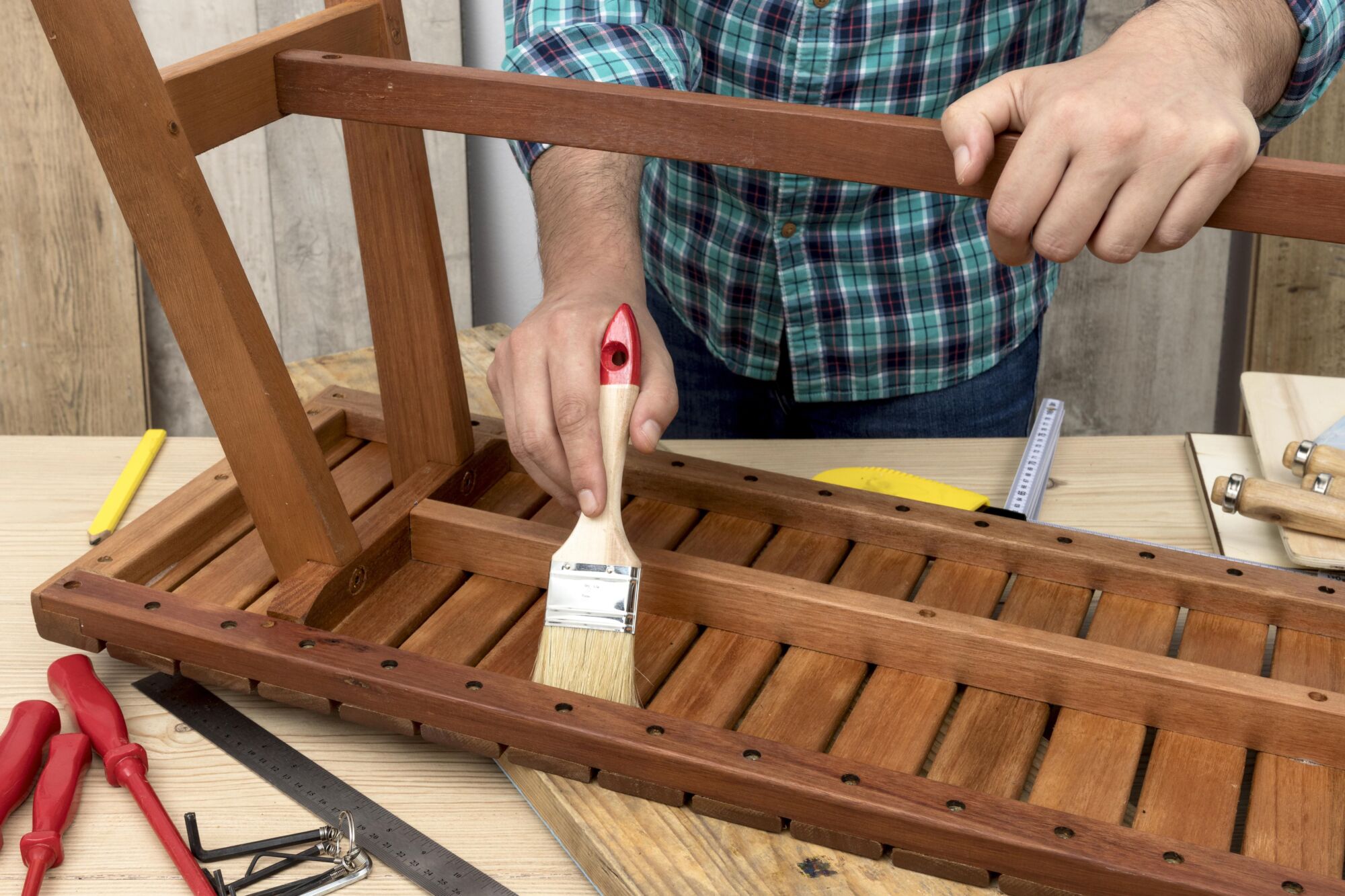 pessoa restaurando mesinha de madeira com pincel